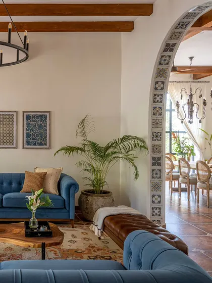 The main living area of the Goan villa, where a tiled archway frames the view into the dining room. The design blends Portuguese and Indian influences for a unique vacation vibe.