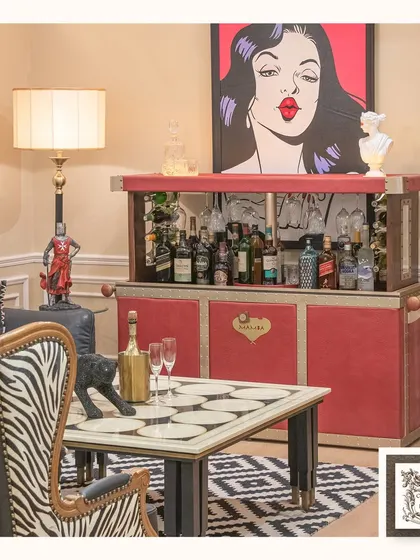 This pop art print adds a playful and glamorous vibe to this entertainment space. Paired with a bold red automated bar, it creates a fun, retro-inspired corner for hosting guests.
