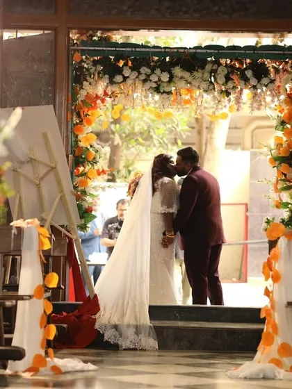 This is the moment it all becomes real. I love capturing this first kiss as husband and wife, framed by a beautiful floral arch we designed just for them. This view from the aisle shows how every detail, from the pew flowers to the grand entrance, comes together for a perfect picture.
