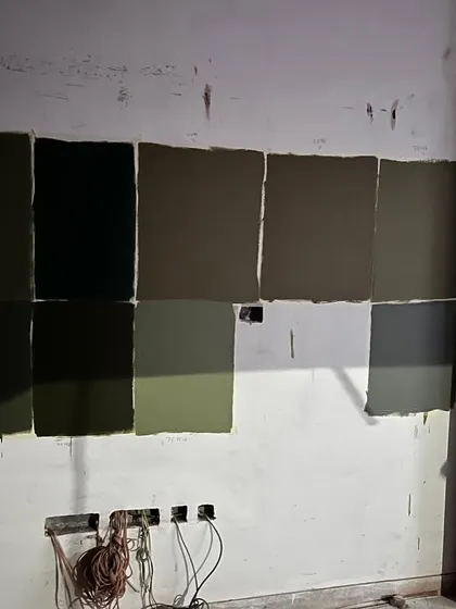 Finding the perfect color is a process. This image shows the numerous paint samples we tested on the wall for the Jhansi project to get the exact shade of olive green. It's this attention to detail that makes a difference.