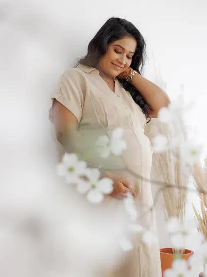A dreamy, soft-focus shot from a maternity session. The natural makeup look with gently waved hair enhances her features without overpowering her natural beauty.