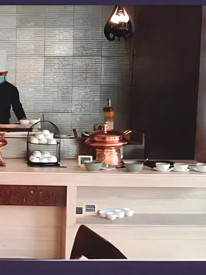 A chef at an indoor live station, ensuring all hygiene standards are met while preparing fresh food for guests. This setup is perfect for office lunch catering and seminars.