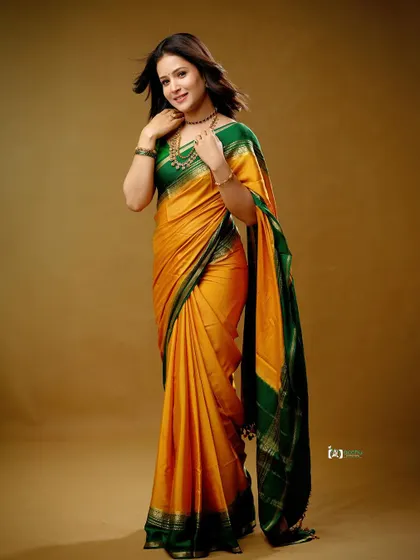 This pose highlights the beautiful contrast between the green and yellow silk. It’s a classic and elegant portrait that celebrates traditional Indian fashion.