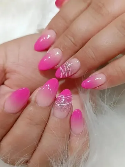 A bright pink ombre set with abstract white line art on the accent nails for a modern, artistic touch.