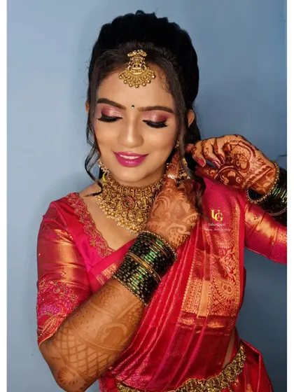 A candid shot of Geetha getting her final touches. This photo captures the intricate details of her reception look, from the perfectly placed earring to the flawless finish of her makeup.