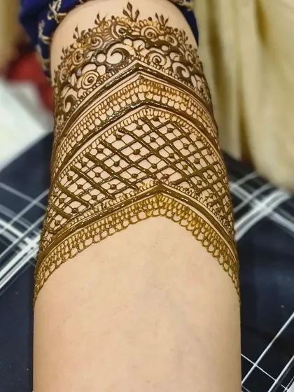 A detailed shot of a geometric armband. This pattern features a crisp jaal (net) design framed by intricate borders.