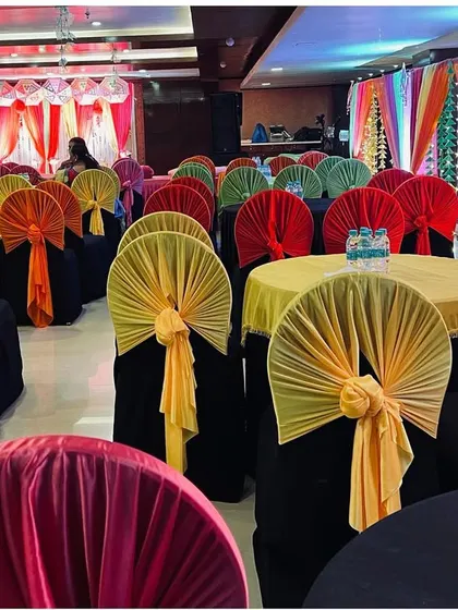 Colorful seating arrangements for a Mehendi or Sangeet night, with bright drapes tied to the chairs.