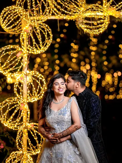 A sweet, candid moment between a couple at their evening reception, surrounded by magical bokeh from the fairy lights.