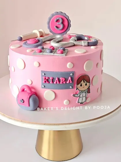 A different angle of the doctor-themed cake for Kiara, showing the little doctor bag and name plaque. It's a fun, personalized cake for a future lifesaver.