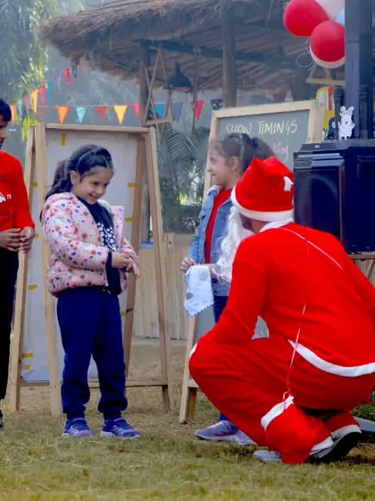 Santa kneeling down to talk to a group of children, creating a magical Christmas memory.