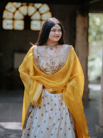 The happy couple glowing in "yellove." We designed this Haldi setting to be both traditional and fresh, with a backdrop of rich greenery that beautifully complemented their yellow outfits.
