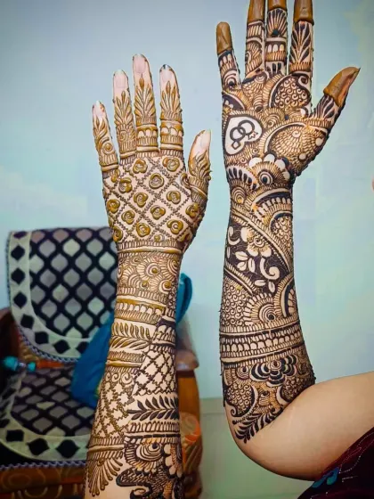 A stunning engagement mehandi design with the initial 'S' and interlocking rings. The back of the hand features a prominent jaali pattern.