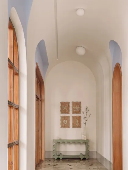 The 'Etheria' console table, with its elegant, sculptural form, sits at the end of the L-shaped galleria.