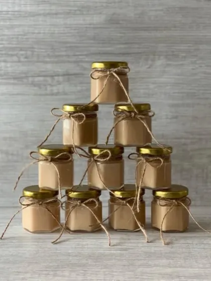 A pyramid stack of hexagonal mini jar candles. These are a unique and stylish option for affordable favors.