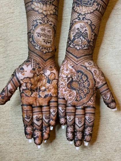 A stunning design with a large lotus on one palm and a peacock on the other, both surrounded by intricate patterns. The arms feature a Bengali quote and lovebirds.