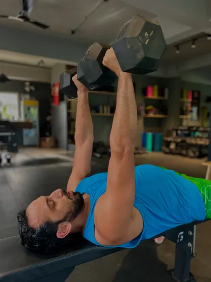 The dumbbell bench press is a staple for building chest, shoulder, and tricep strength. Using dumbbells helps ensure both sides of the body are working equally.