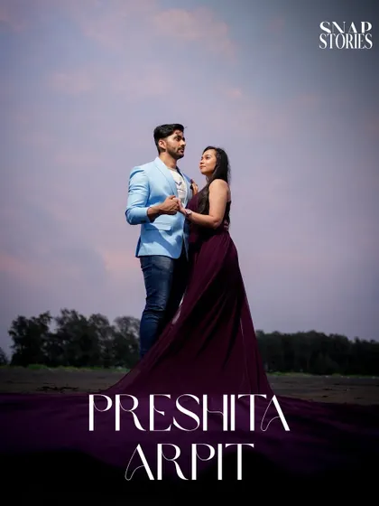 A romantic portrait of the couple standing together on the beach at dusk, creating a moody and atmospheric pre-wedding photograph.