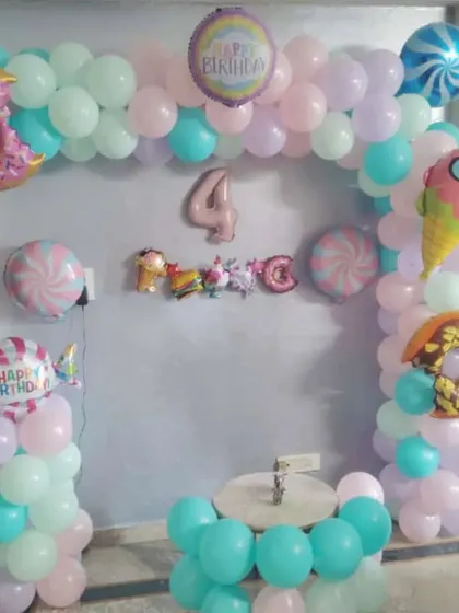 A sweet Candy Land theme for a 4th birthday. This decoration includes donut and ice cream foil balloons to create a delicious-looking party setup.