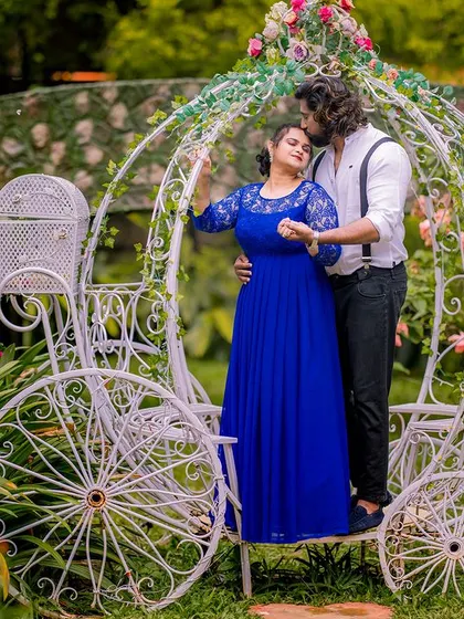 A tender kiss on the forehead in a beautifully decorated Cinderella carriage. The bride's blue lace gown adds a touch of elegance to this romantic scene.
