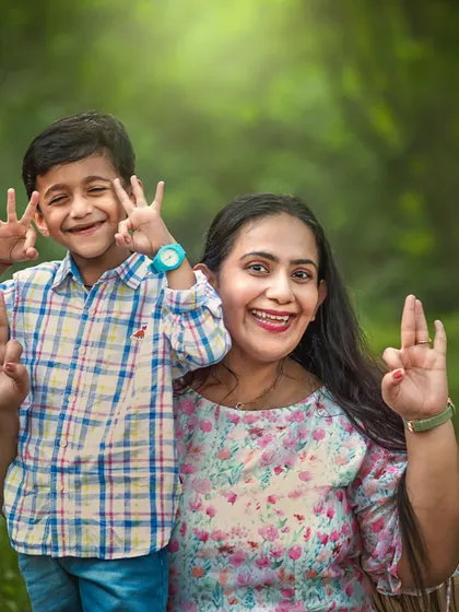 A mother and her son smile and make playful hand gestures for the camera during their outdoor shoot. This fun and silly moment shows the relaxed atmosphere I encourage to get genuine expressions.
