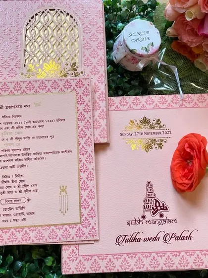 The complete set for a Bengali wedding, featuring a pink laser-cut folder and inserts with traditional motifs and Bengali script.