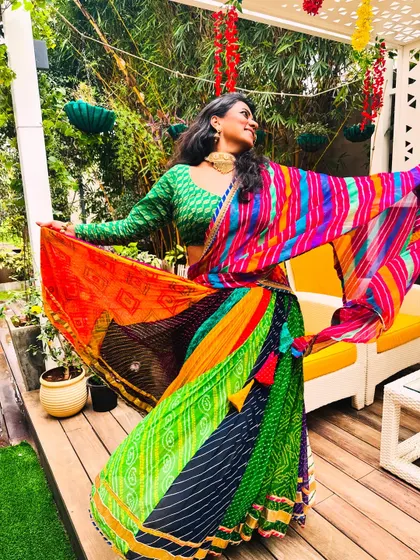 A candid moment during a photoshoot for Teej. The vibrant colors of my lehenga perfectly match the festive and celebratory mood of my folk dances.