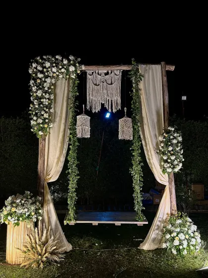 This dreamy boho-chic swing was the perfect photo spot for a 25th anniversary. We used rustic wood, flowing drapes, lush white florals, and delicate macrame details to create a romantic and elegant setting for the happy couple.