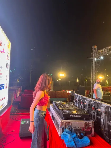A side view of my setup at the Dandiya event, with a large screen displaying event information next to the stage.