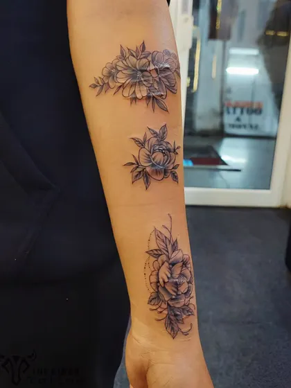 This client wanted to turn a history of self-harm scars into something beautiful. We designed a delicate floral piece that flows along the forearm, using fine-line flowers and soft shading to completely conceal the scars and create a new, positive story.