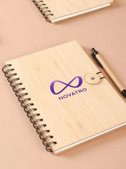 An eco-friendly notebook with a wooden cover, customized for Novatro.ai. This is a great example of combining sustainability with professional branding.