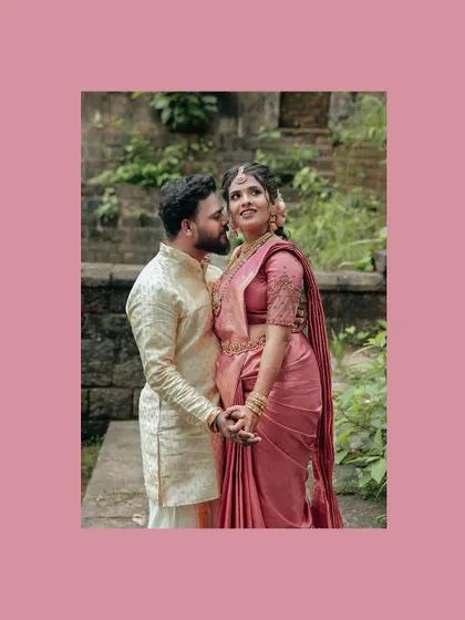 A loving portrait of a couple standing together, framed in a soft pink border.