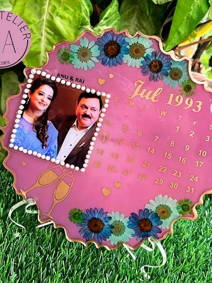 A pearl anniversary deserves a special celebration. This pink resin calendar frame commemorates a July 1993 wedding, complete with champagne glass details and beautiful blue flowers.