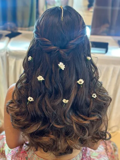 Elegance in every petal and every curl. This half-up style features a simple twist and is adorned with small, delicate white flowers.