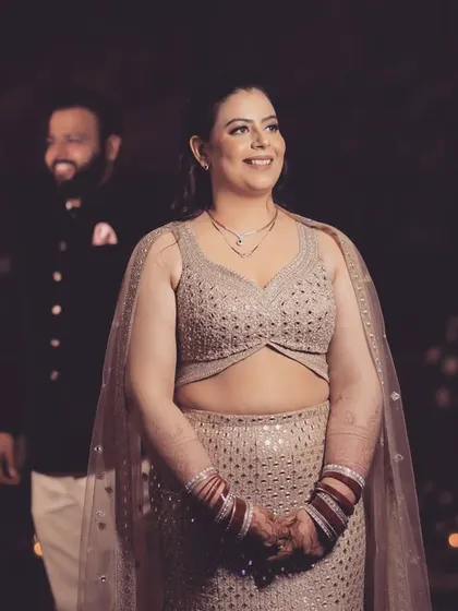 In your eyes, the world feels steady. A beautiful candid shot of the bride, with the groom smiling in the background, perfectly capturing a moment of quiet happiness.