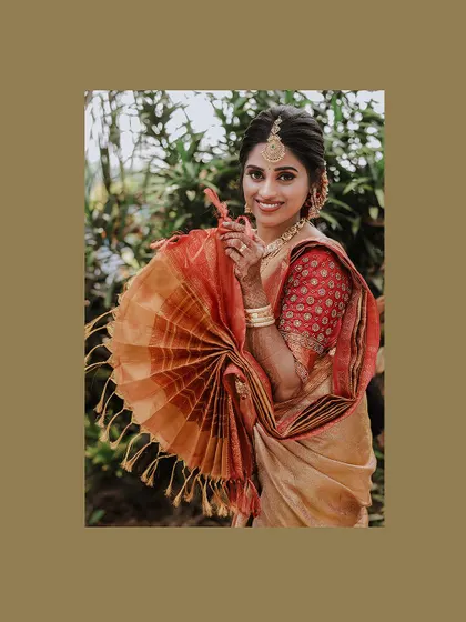 A playful portrait of the bride with a fan made from her saree's pallu.