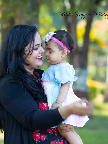 A candid and emotional shot of a mother holding her one-year-old daughter, their faces close together in a moment of pure connection and love.