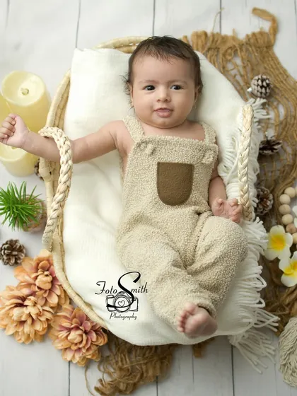 This little one looks so content in his basket. The natural elements like pinecones and flowers add a beautiful, organic touch to this newborn portrait.