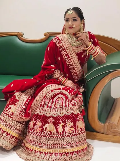 The bride seated, showcasing the intricate details of her lehenga and makeup. The look was designed to be elegant whether standing or sitting.