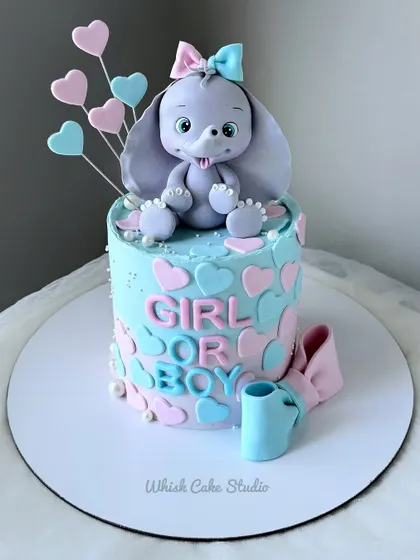 The cutest gender reveal cake. This non-fondant cake features an adorable elephant and is decorated with pink and blue hearts, asking "Girl or Boy?"