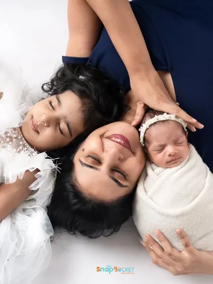 A mother's love, pictured with both her daughters. This overhead shot creates a beautiful, intimate portrait of a mom and her children, a treasure for years to come.