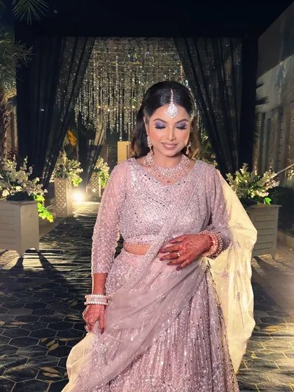 The full look against the beautiful evening decor. The glamorous makeup and elegant outfit make her the center of attention.
