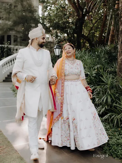 Love shines bright. A candid shot of a couple walking through a garden in Goa, the bride's laughter lighting up the frame.