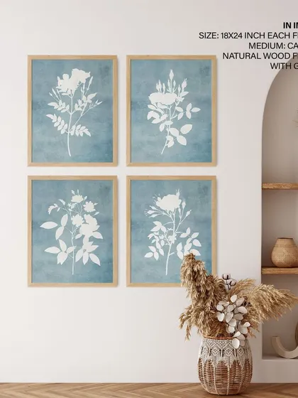 Create a soft and serene gallery wall with this set of four botanical silhouette prints. The white floral designs against a textured light blue background, framed in natural wood, bring a gentle, rustic charm to this boho-chic space.