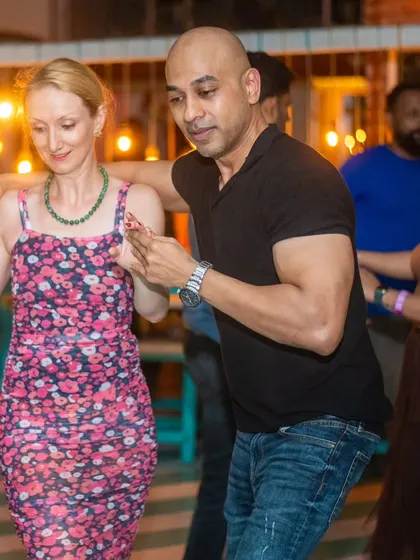 A stylish pair dancing with focus and grace. The floral dress adds a touch of elegance.