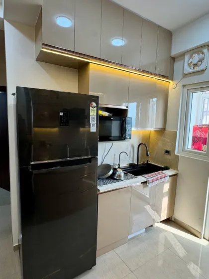 This kitchen corner is designed for efficiency. We placed the refrigerator next to the sink and microwave unit, creating a practical work triangle.
