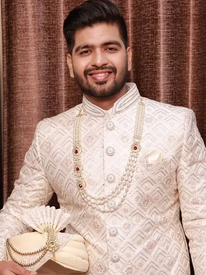 A close-up of the groom holding his turban. This highlights the flawless skin finish and the subtle definition that makes the groom look fresh and ready for his big day.