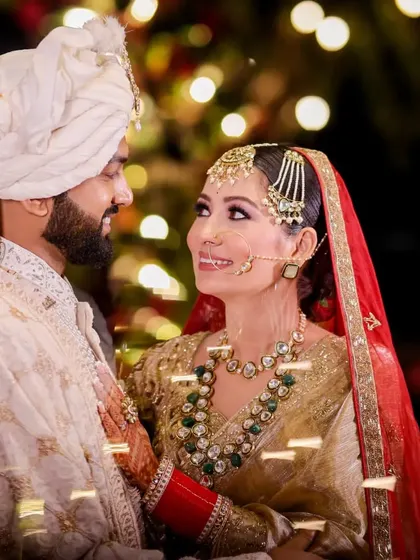 A beautiful, candid moment between the bride and groom. The soft, warm lighting from the bokeh background adds a magical feel to their shared glance.