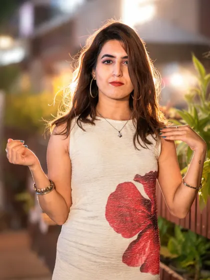I'm looking straight at the camera in my red-flower dress, away from the microphone in Anurag Gupta's artist portraits.