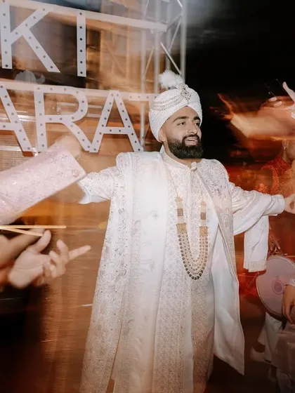 A motion-blur shot of the groom during his baraat. This technique conveys the high energy and excitement of the procession.