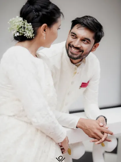 A close-up of a couple sharing a private joke, their genuine smiles lighting up the frame.